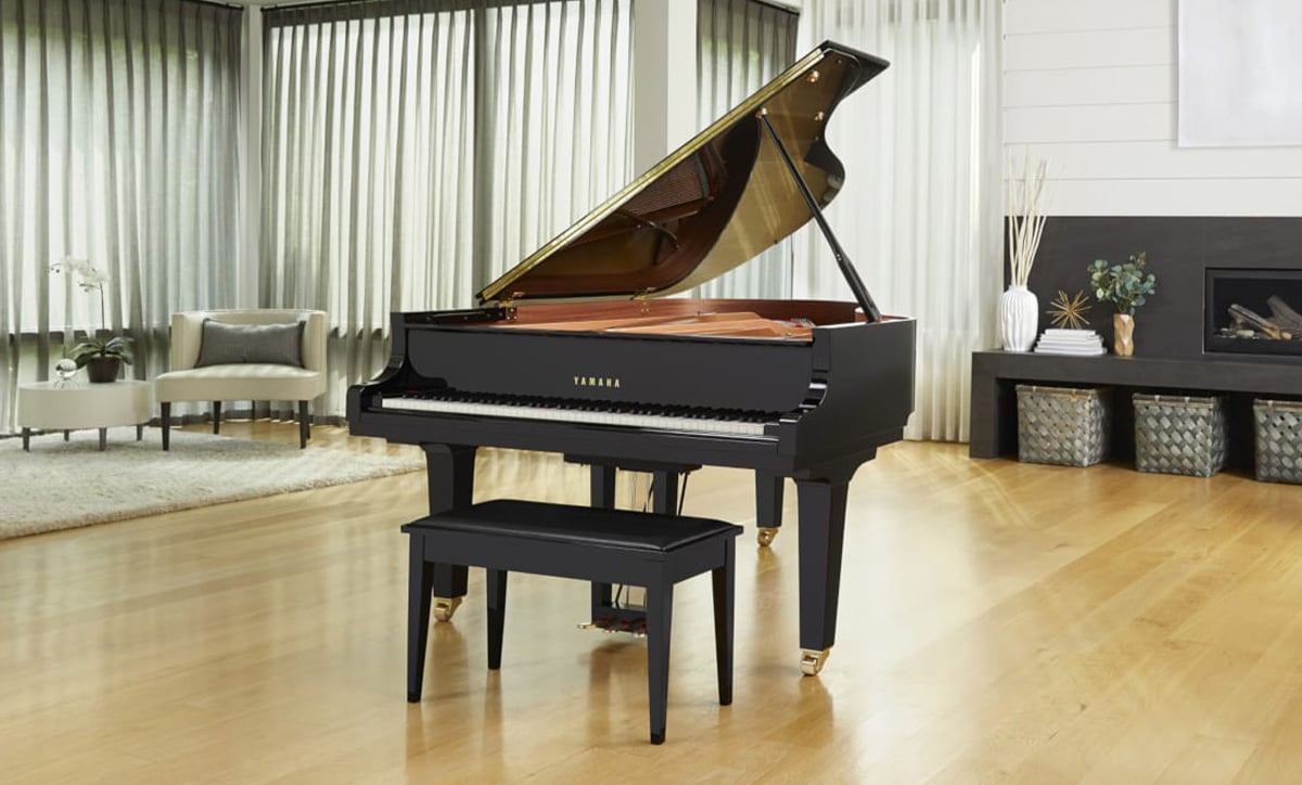 Yamaha grand piano with polished ebony finish and matching bench, highlighting craftsmanship and elegance for a perfect sound.