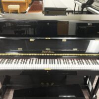 Pearl River upright piano with glossy black finish in a showroom setting.