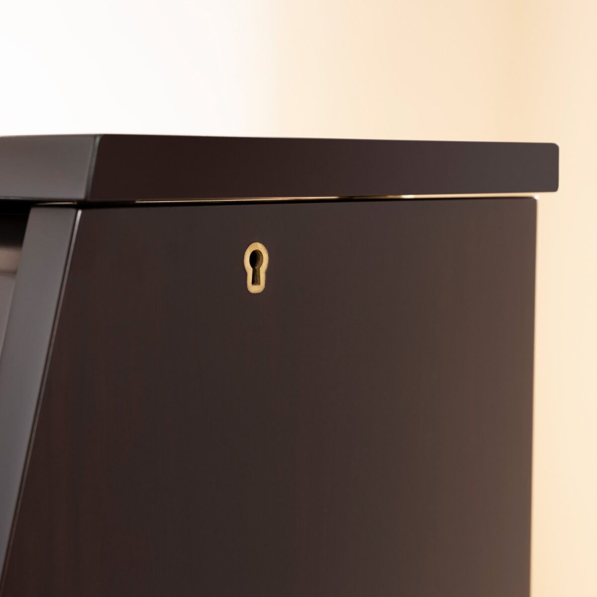 Detailed view of polished ebony upright piano cabinet with keyhole from Las Vegas Pianos.