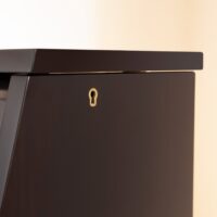 Detailed view of polished ebony upright piano cabinet with keyhole from Las Vegas Pianos.