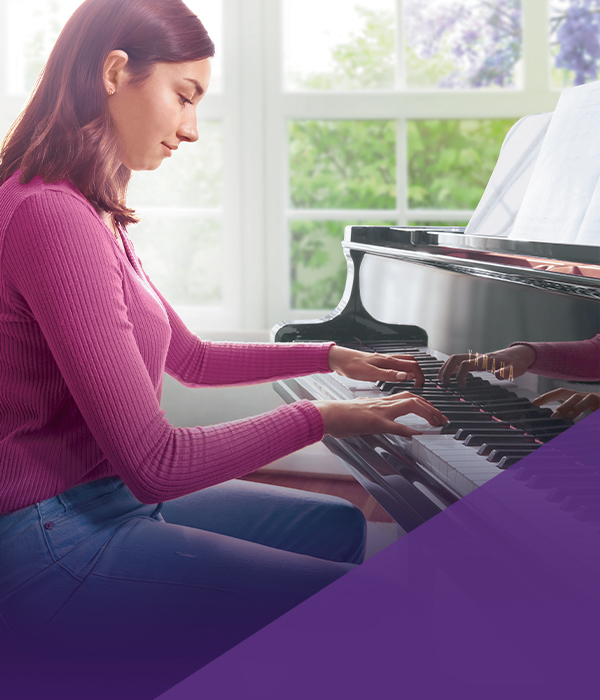 Novice pianist playing a glossy black Yamaha grand piano, showcasing elegant sound and craftsmanship.