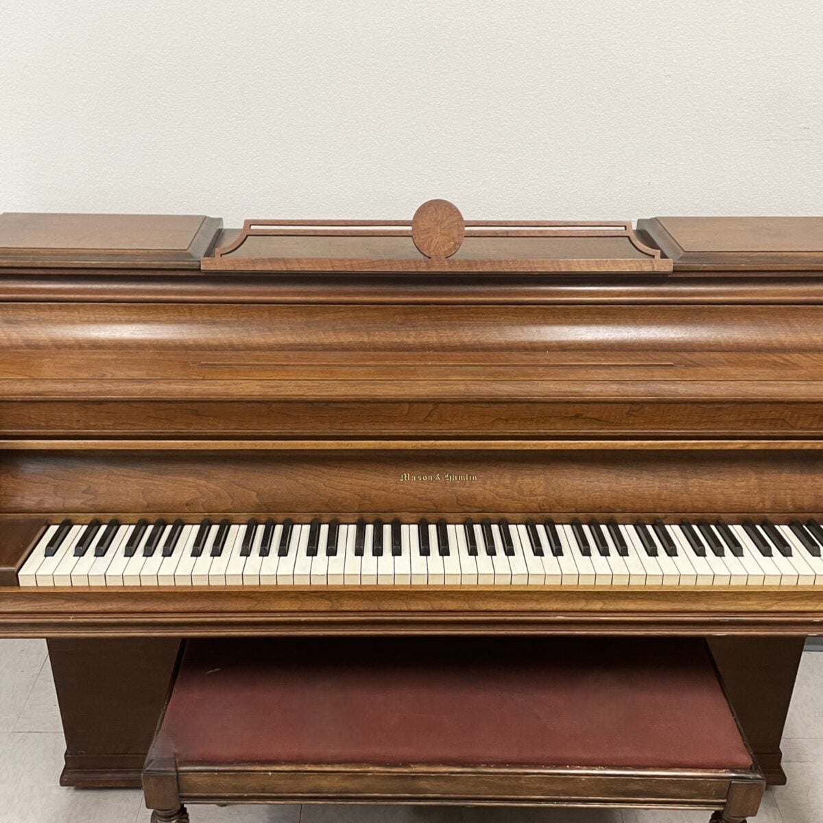 Alt text: Mason & Hamlin upright piano with polished mahogany finish and detailed cabinetry, perfect for any music lover.